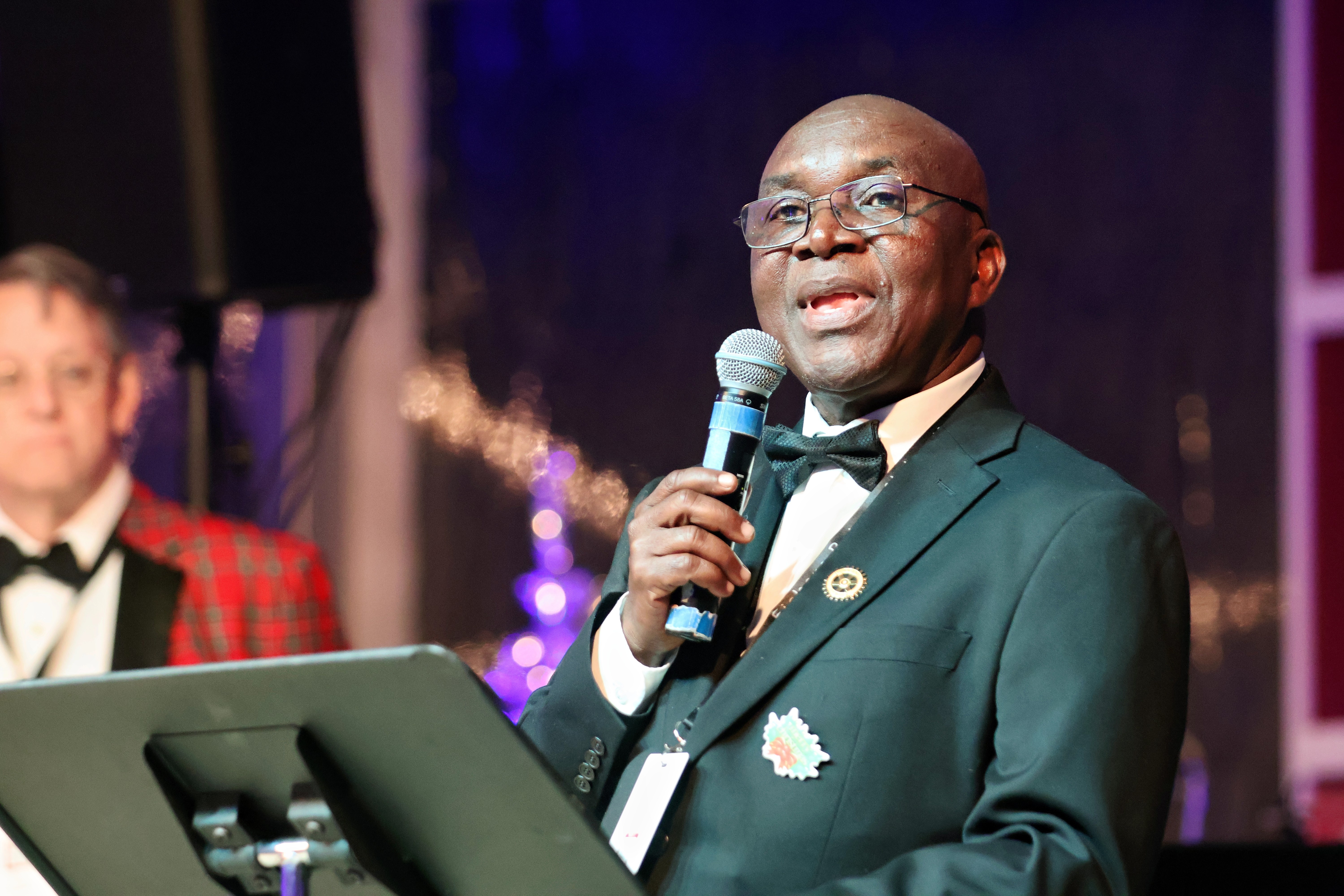 A WaterIsLife Charity Ball speaker addressing guests with a microphone